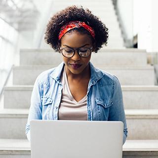 Student working on laptop in a stairwell